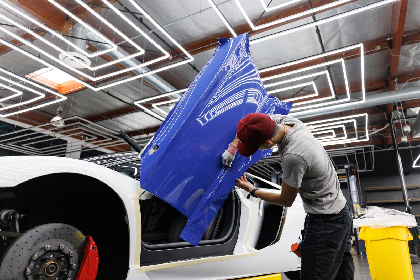 Installer fitting blue film to a car door